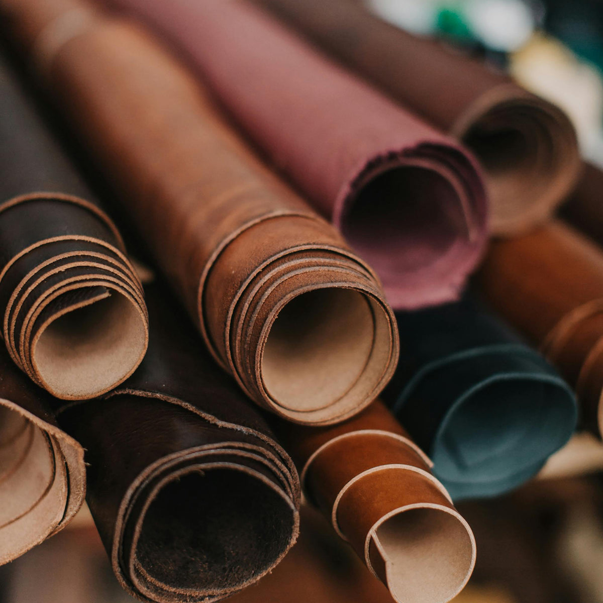 Stack of leather rolls in various colors with a blurred background